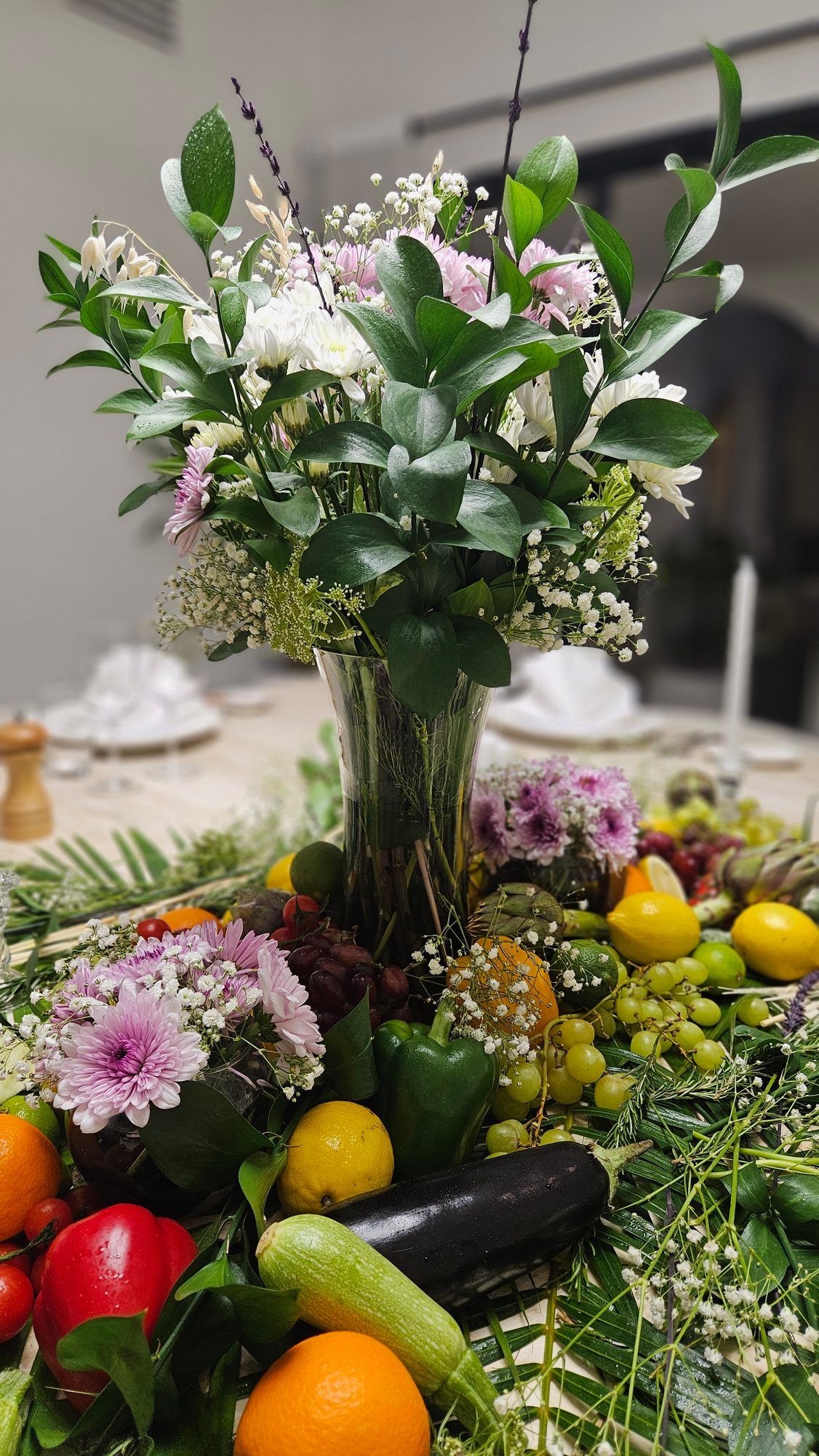 Dining table dressed with a fresh-produce centrepiece.