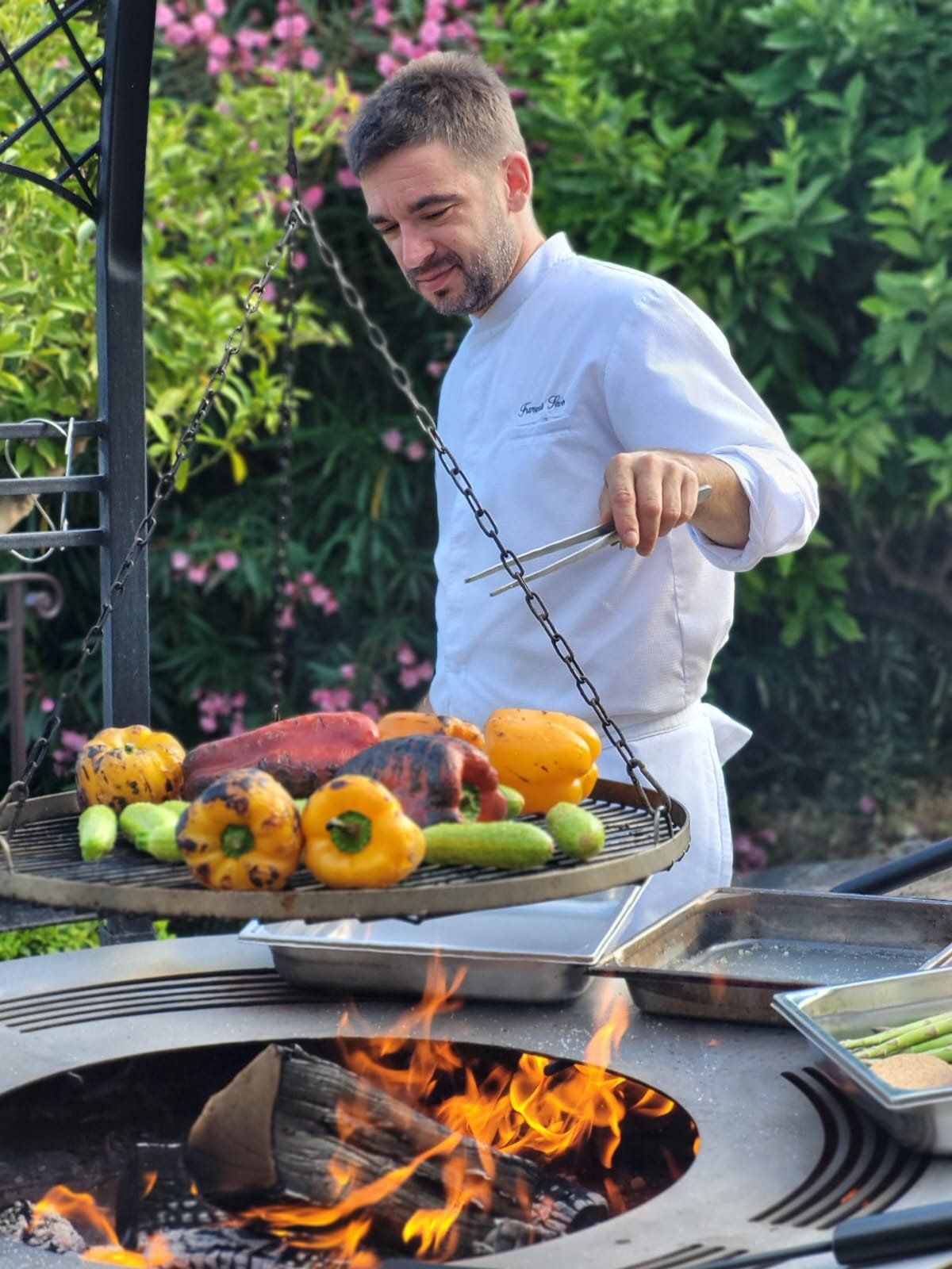 The chef grilling vegetables over fire.