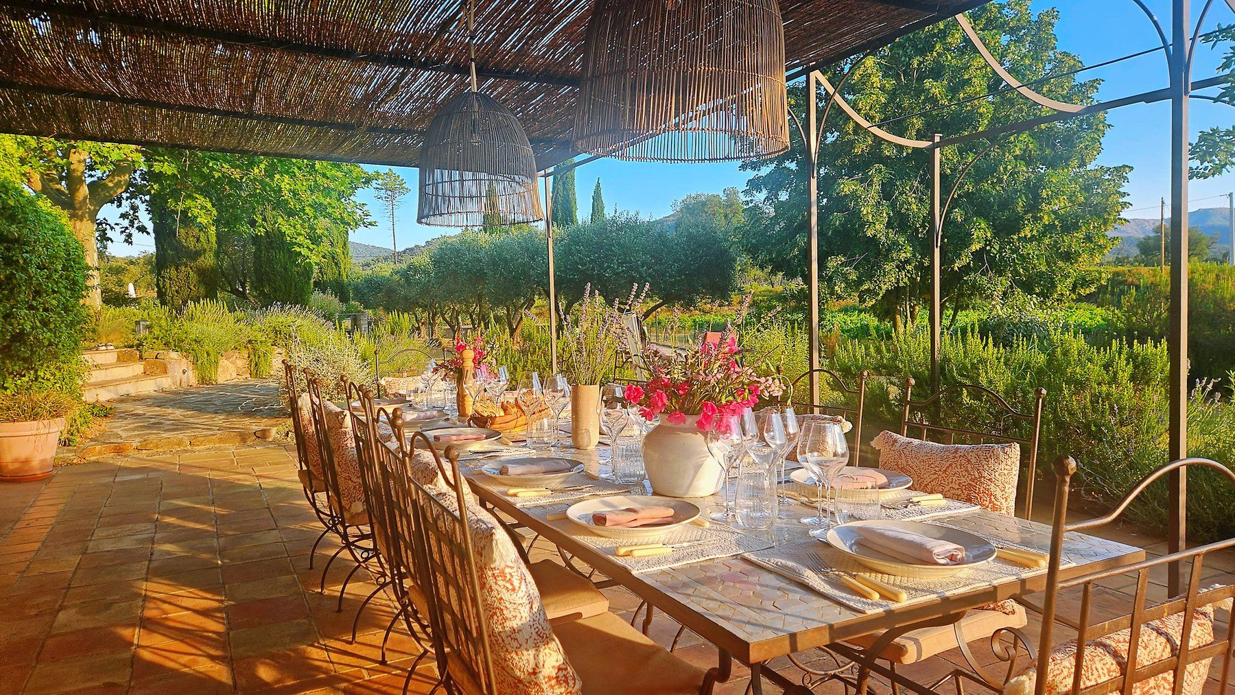 Garden-terrace table under a reed canopy.