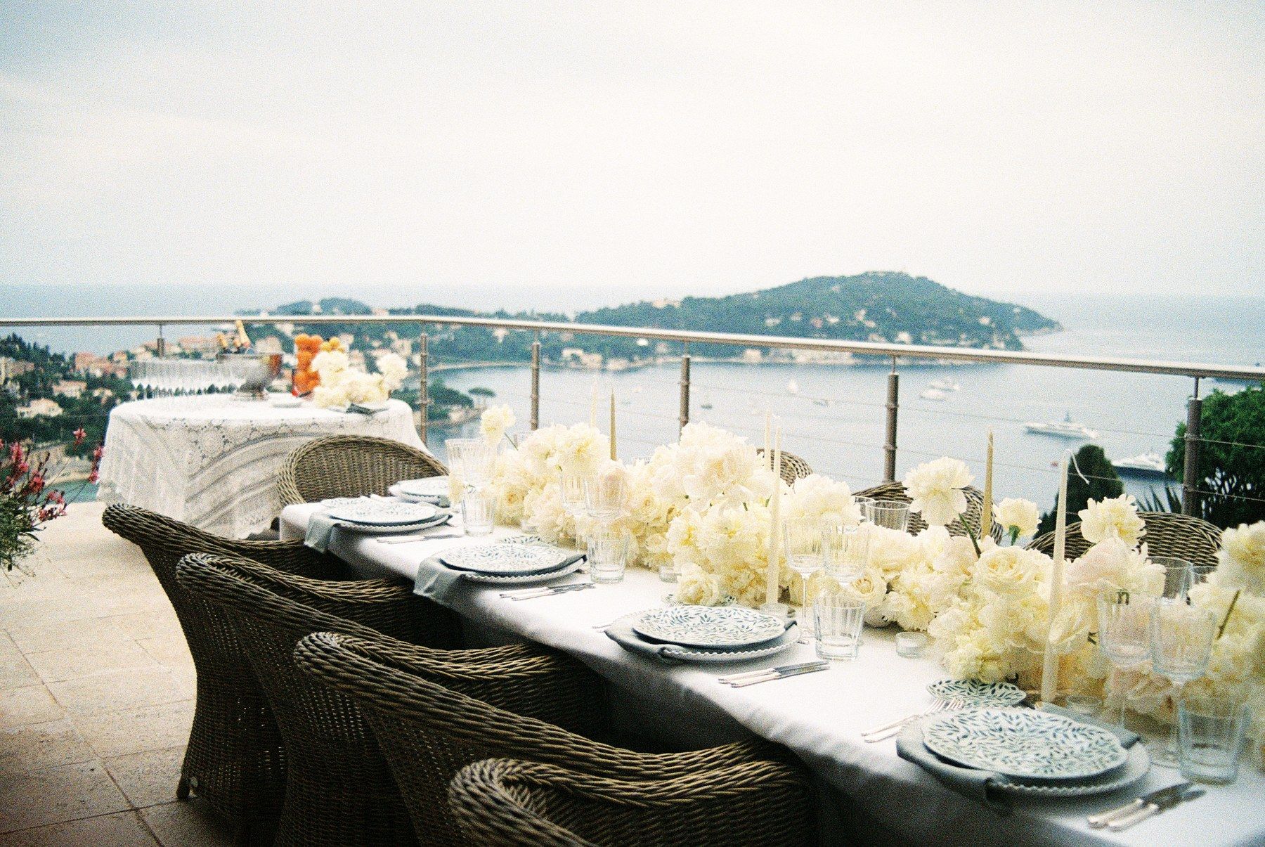 Top-down detail of a Riviera tablescape with white flowers.